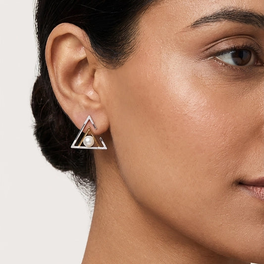 Close-up of a woman wearing a silver earring with a pearl