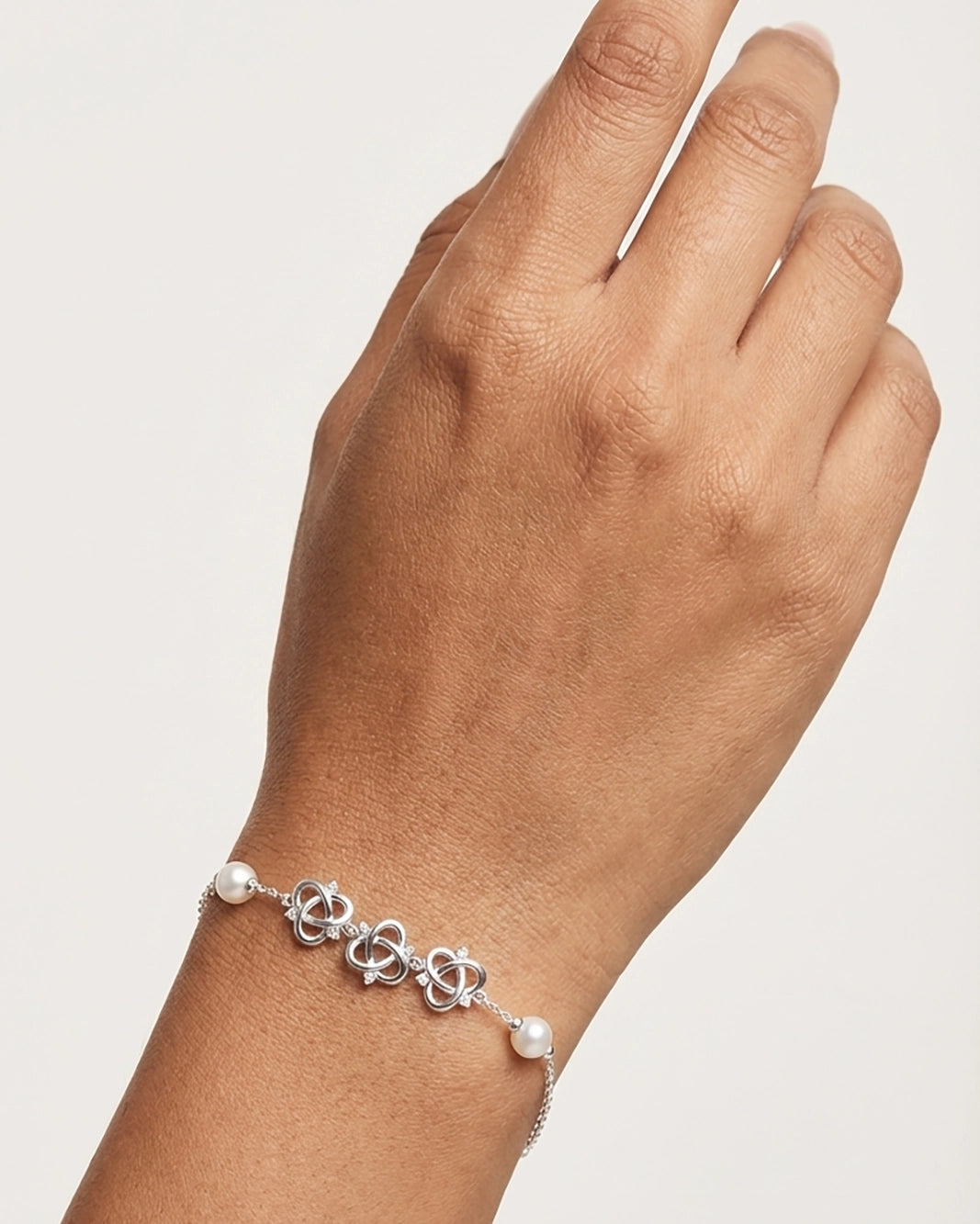 Close-up of a silver pearl bracelet worn on a wrist, showcasing a stylish silver kada bracelet for women.
