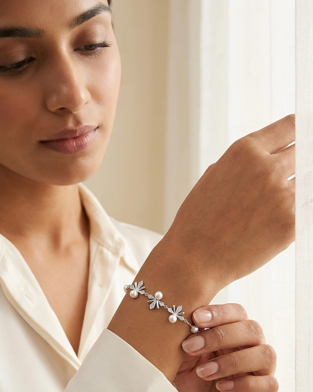 Woman wearing a silver bracelet with floral designs, close-up of hand and bracelet by Sohvii