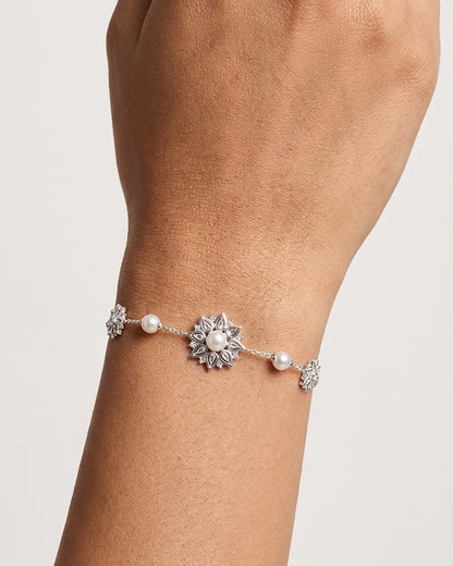 Dainty Silver Snowflake Bracelet with Pearls and Diamonds worn on a Person's Wrist