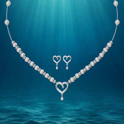 Silver heart jewelry set displayed against a deep blue, ethereal underwater-themed background