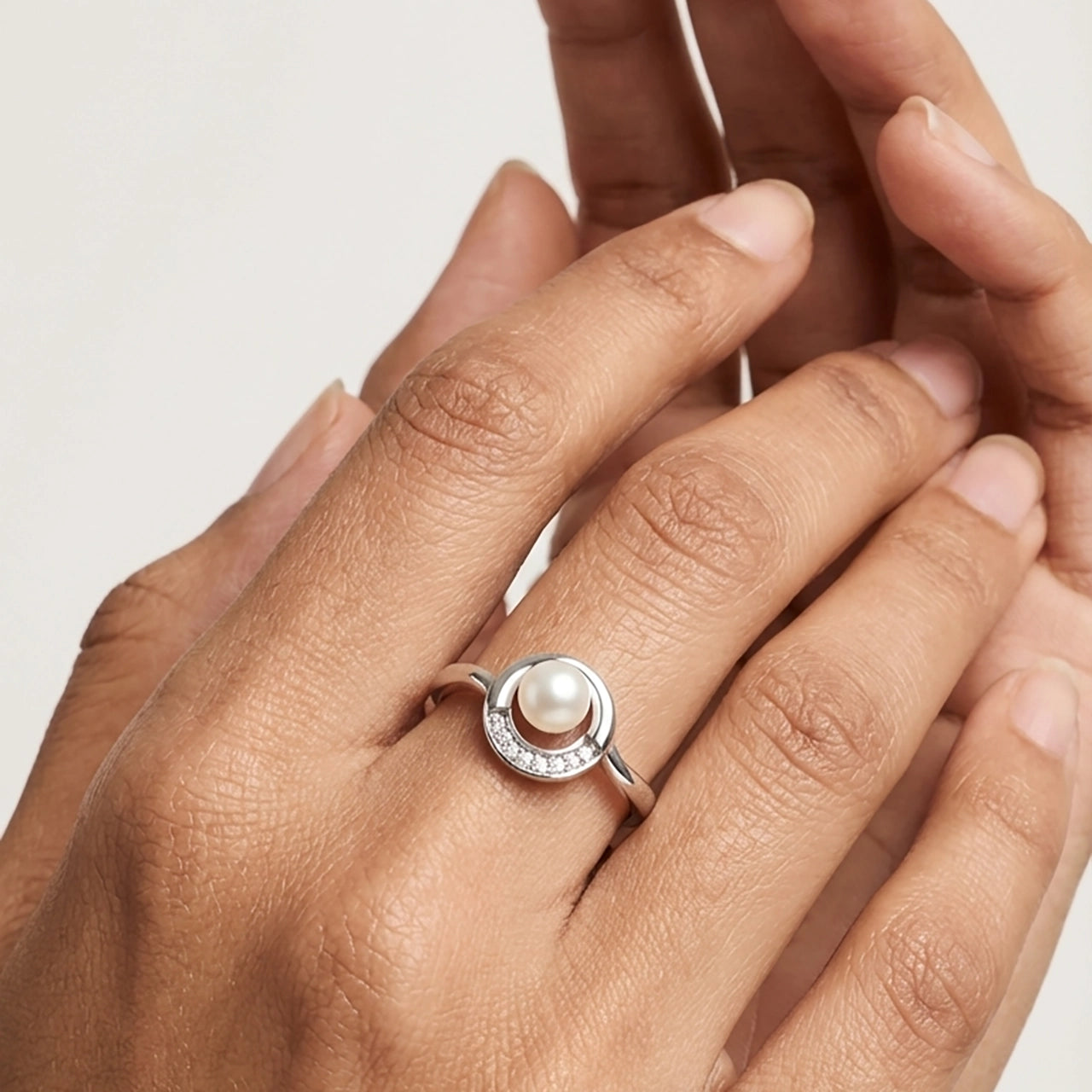 Silver Pearl Moon Ring with Diamond Detailing worn on a Person's Hand.